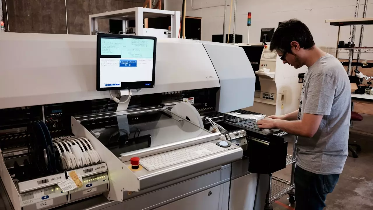 Figure 1: Dustin Holliday working on the My200. He is loading the tray feeder. Figure 1: Dustin Holliday working on the My200. He is loading the tray feeder.
