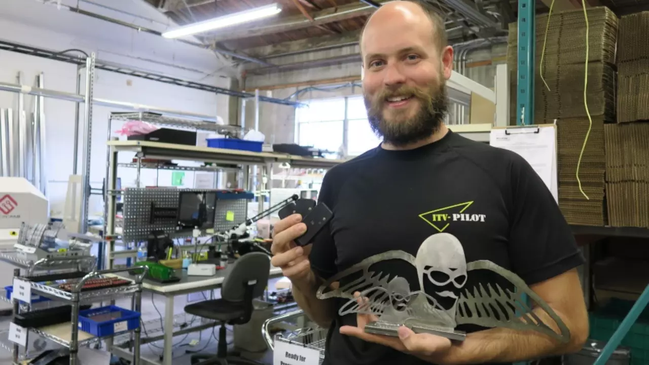 Figure 4: Trey German hold up his trophy and his paramotor monitoring flight hardware. Figure 4: Trey German hold up his trophy and his paramotor monitoring flight hardware.